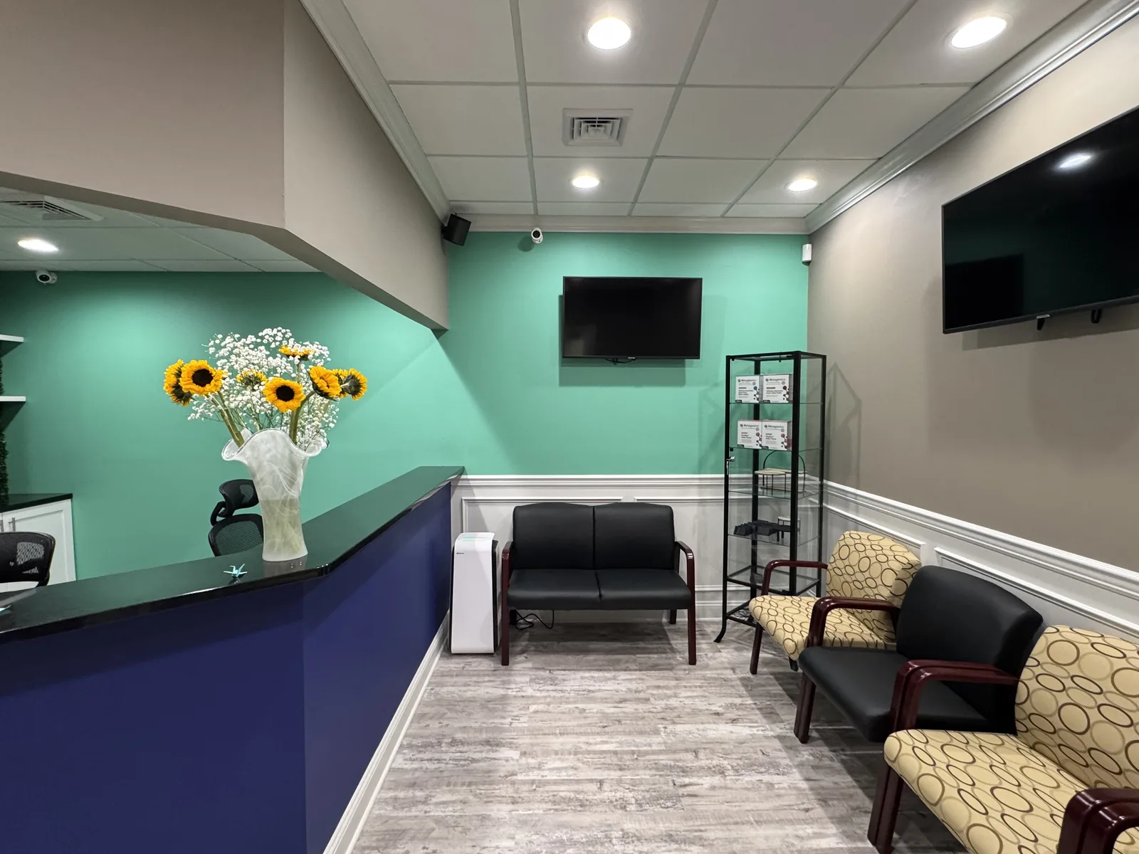 The reception and waiting area inside the Princeton Healing Arts suite, with comfortable seating and fresh sunflowers